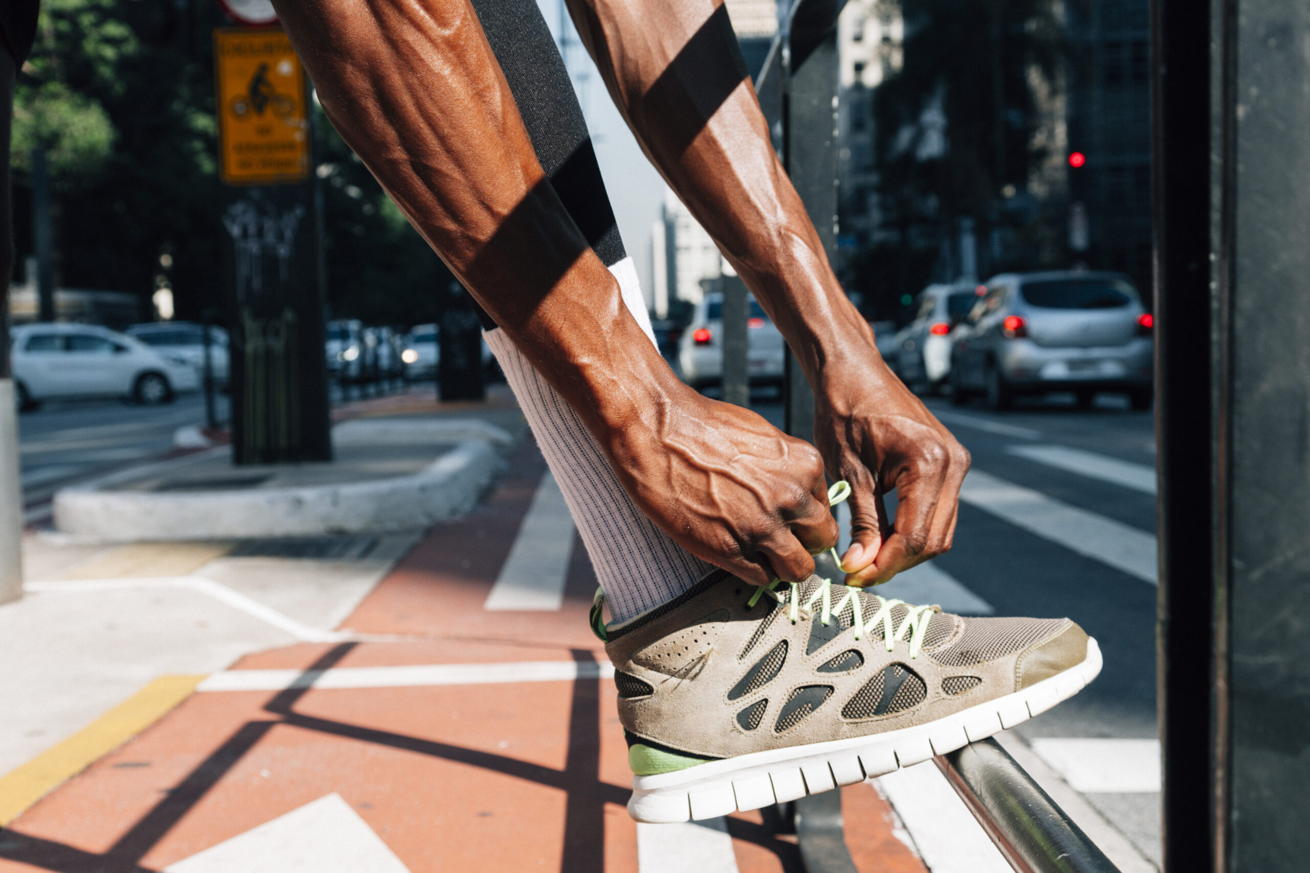 A man tying the shoelaces of his replica shoes.